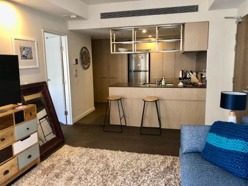 a living room with a couch and a kitchen at Modern Spacious City Pad with Rooftop Pool and Gym in Sydney