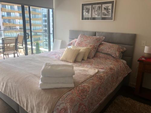 a bedroom with a bed with towels on it at Modern Spacious City Pad with Rooftop Pool and Gym in Sydney