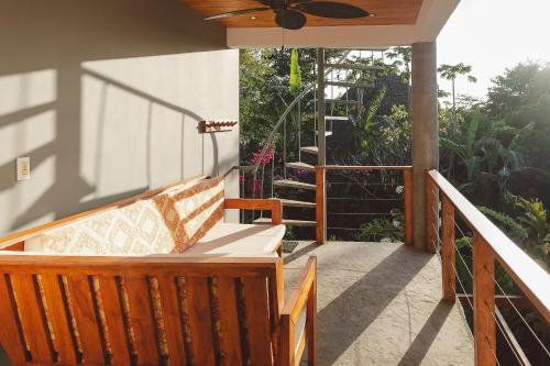 a porch with a bench and a stair case at Iluminar Beachfront Suites in Nosara