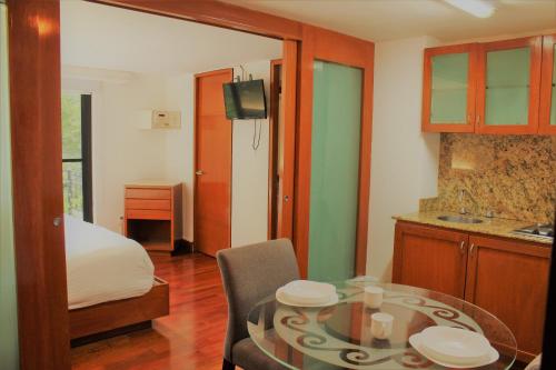 a room with a table and a bed and a kitchen at Condesa Suites in Mexico City