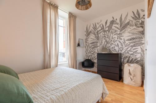 een slaapkamer met een bed en een plantenwand bij Villa Alaisienne Confort in Chamalières