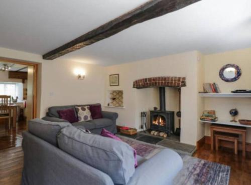 sala de estar con sofá y chimenea en Church Gate Cottage - Bridestowe en Bridestowe