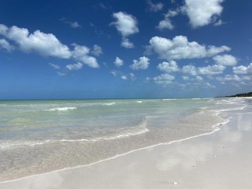 a sandy beach with the ocean and clouds in the sky at Casa Colibrí El Cuyo in El Cuyo