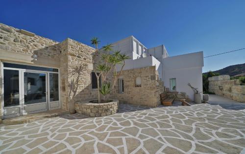 a house with a stone yard with a potted plant at New Villa Komos in Pitsidia,Matala,Crete in Pitsidia
