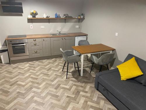 a living room with a couch and a table and a kitchen at The Corner Apartment in Carlow