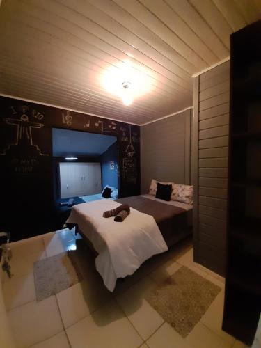 a bedroom with two beds and a light on the wall at Chalet Sonho de Sophia in Urubici