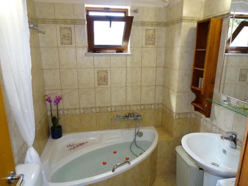 a bathroom with a tub and a sink at Zafeiria's Suite in Vamos