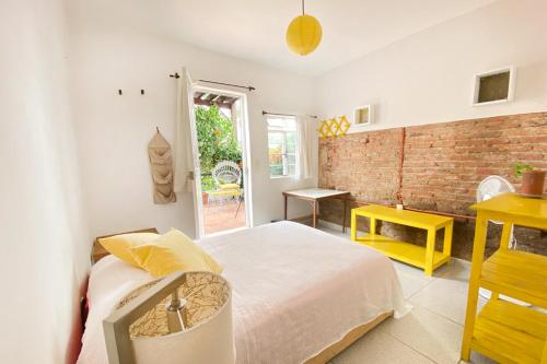 a bedroom with a bed and a brick wall at Casa Canario Hostel in Guadalajara