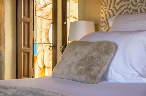 a close up of a bed with a blanket on it at La Maison du Passage - Chambres - Suites premium, Spa, Piscine et Restaurant in Martignargues