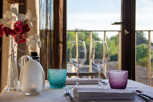 a table with three wine glasses on a table at La Maison du Passage - Chambres - Suites premium, Spa, Piscine et Restaurant in Martignargues
