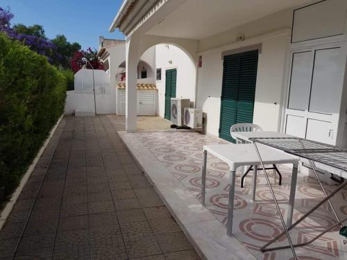 a patio with a table and chairs in front of a building at Altura Beach House in Altura