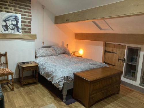 1 dormitorio con cama y pared de ladrillo en Colts Neck Cottage Upper Hopton, Mirfield, West Yorkshire en Mirfield