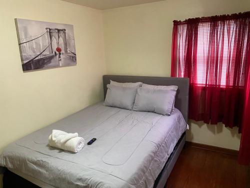 a bed in a bedroom with red curtains at Nice 3 Bdr FREE Wine, Wi-fi and Parking in Milwaukee