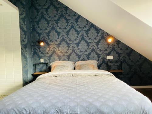 a bedroom with a large bed with blue wallpaper at Charmant T2 atypique Industriel in Dunkerque