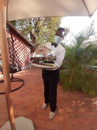 马普托PolanaHibiscosLodge&Spa的戴面具的人,带着托盘的食物