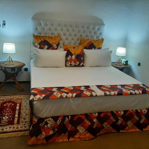 a bedroom with a large bed and two lamps at PolanaHibiscosLodge&Spa in Maputo