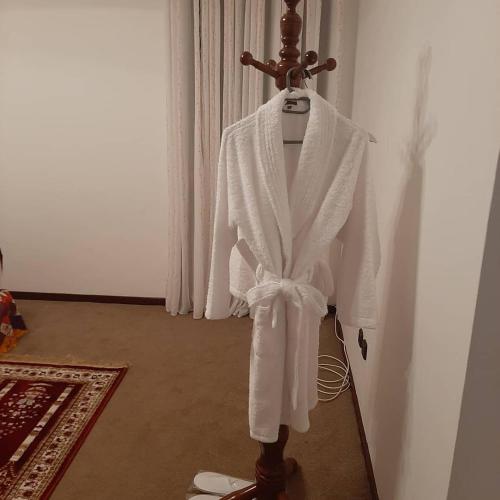 a white robe is hanging on a wall at PolanaHibiscosLodge&Spa in Maputo