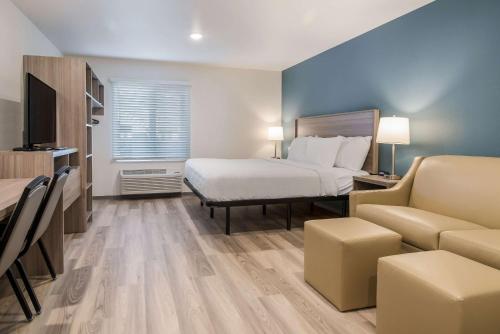 a hotel room with a bed and a couch at WoodSpring Suites Portland Vancouver in Vancouver