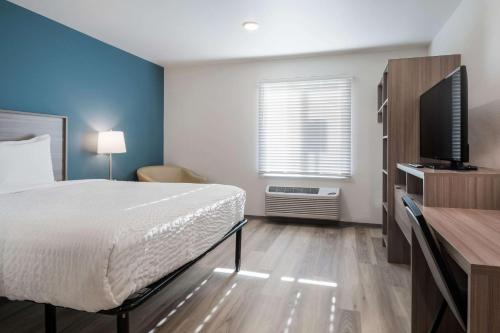 a bedroom with a bed and a television in it at WoodSpring Suites Portland Vancouver in Vancouver