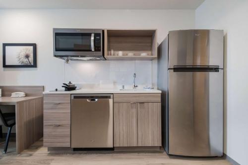 a kitchen with a stainless steel refrigerator and a sink at WoodSpring Suites Portland Vancouver in Vancouver