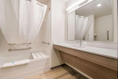 a white bathroom with a sink and a mirror at WoodSpring Suites Portland Vancouver in Vancouver
