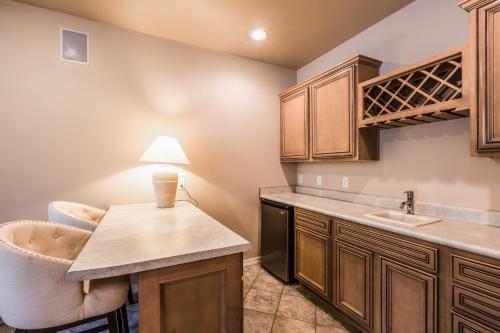 uma cozinha com armários de madeira, um lavatório e uma cadeira em Stoney Way em Flagstaff
