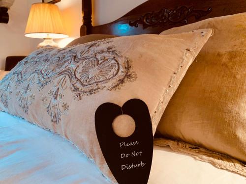 a pillow with a sign on it sitting on a bed at Busfeild Arms in Keighley