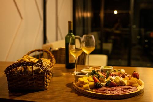 a table with a plate of food and a glass of wine at Container ABOBORA na natureza da Serra Gaúcha in Flores da Cunha