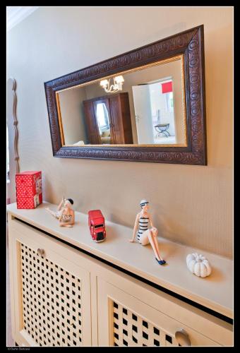a bathroom vanity with a mirror and a doll sitting on it at Auberge De La Gaichel in Gaichel