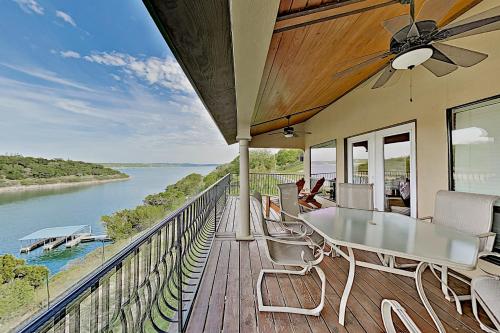 einen Balkon mit einem Tisch und Stühlen sowie Flussblick in der Unterkunft Shiraz & Chardonnay Haus in Lago Vista