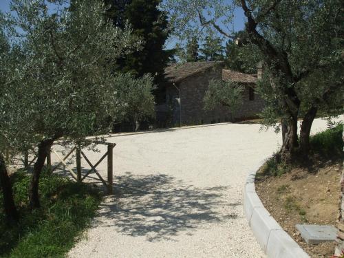 a driveway with a building and trees in front of it at Camere Ramaccia in Assisi