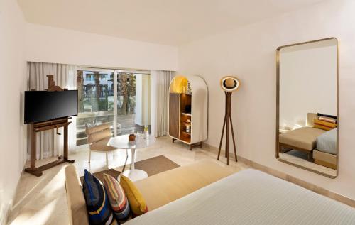 a living room with a bed and a mirror at ME Cabo by Meliá in Cabo San Lucas