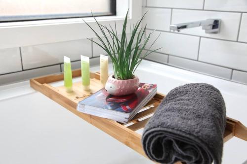 a wooden tray with a plant on a bathroom counter at The Red Door @ Barossa Valley Vineyard View in Nuriootpa