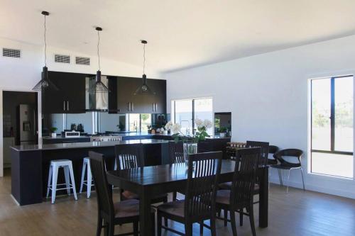 a kitchen and dining room with a table and chairs at The Red Door @ Barossa Valley Vineyard View in Nuriootpa
