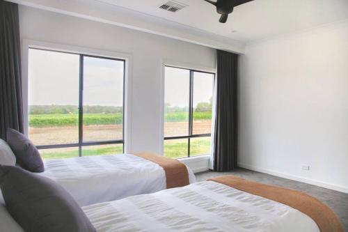 a bedroom with two beds and a large window at The Red Door @ Barossa Valley Vineyard View in Nuriootpa