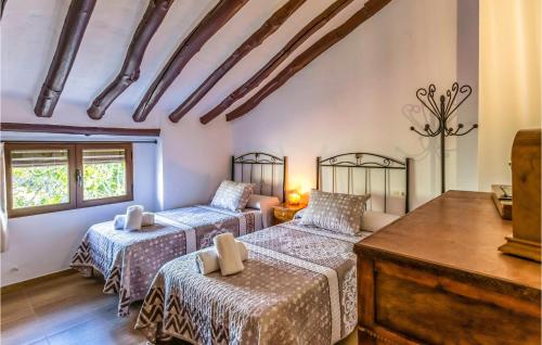 een slaapkamer met 2 bedden, een dressoir en ramen bij Awesome Home In Puertollano With Private Swimming Pool, Can Be Inside Or Outside in Las Caserías