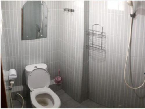 ein Bad mit einem WC und einer Dusche mit einem Spiegel in der Unterkunft Cinere Resort Apartment by Celebrity Room in Tjinere-wetan