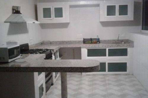 a kitchen with white cabinets and a counter top at Casa con vista espectacular al mar con alberca in Acapulco