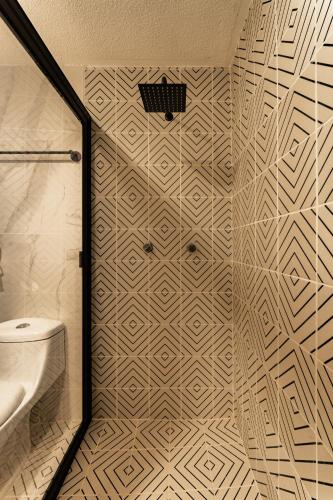 a bathroom with a shower with a toilet and a mirror at Estacion Alameda Downtown in Orizaba