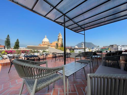 a patio with tables and chairs on a roof at Estacion Alameda Downtown in Orizaba