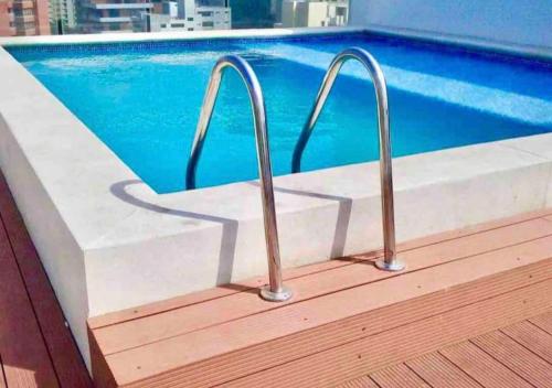 a pool with two metal rails next to a swimming pool at Apartamento en Sector Alto Prado de Barranquilla in Barranquilla