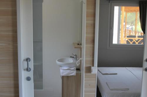 ein kleines Bad mit einem Waschbecken und einem Fenster in der Unterkunft Mobile Homes Jezera in Jezera
