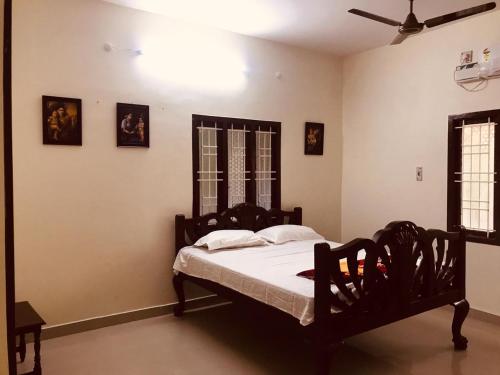 坦贾武尔TANJORE INN的带床和吊扇的卧室