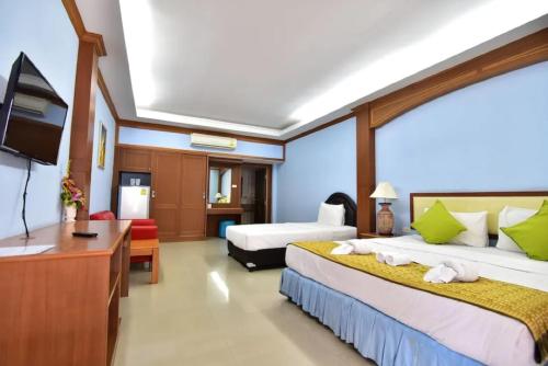 a hotel room with two beds and a television at Ampan Resort & Apartment in Nong Prue