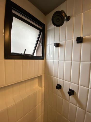 La salle de bains est pourvue d'une fenêtre et de carrelage blanc. dans l'établissement 97 New studio next Paulista Av, fast wifi and balcony, à São Paulo