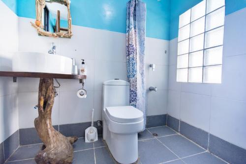 a bathroom with a toilet and a sink at Niu Ohana East Bay Apartments in Boracay