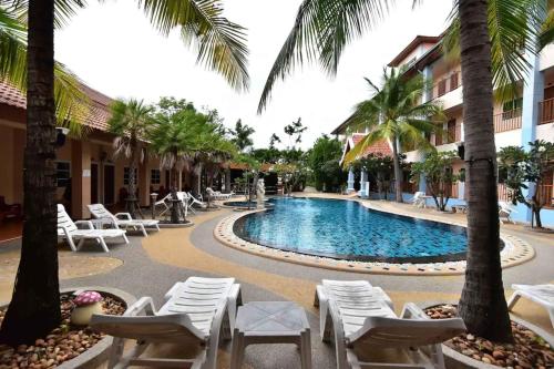 un complejo con una piscina con sillas y palmeras en Ampan Resort & Apartment, en Nong Prue