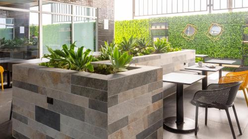 a restaurant with tables and chairs and plants at Holiday Inn Express & Suites - Tijuana Otay by IHG in Tijuana