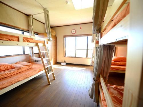 a room with two bunk beds and a ladder at Haruno Guesthouse in Tosa