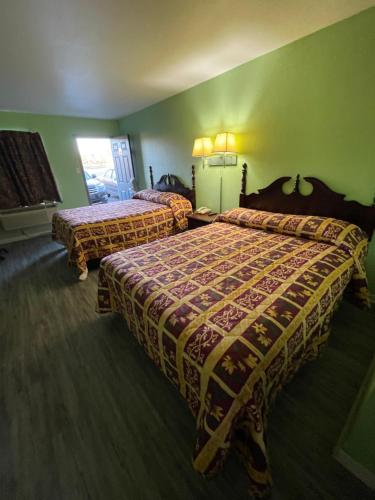 duas camas num quarto de hotel com paredes verdes em Relax Inn Dublin em Dublin